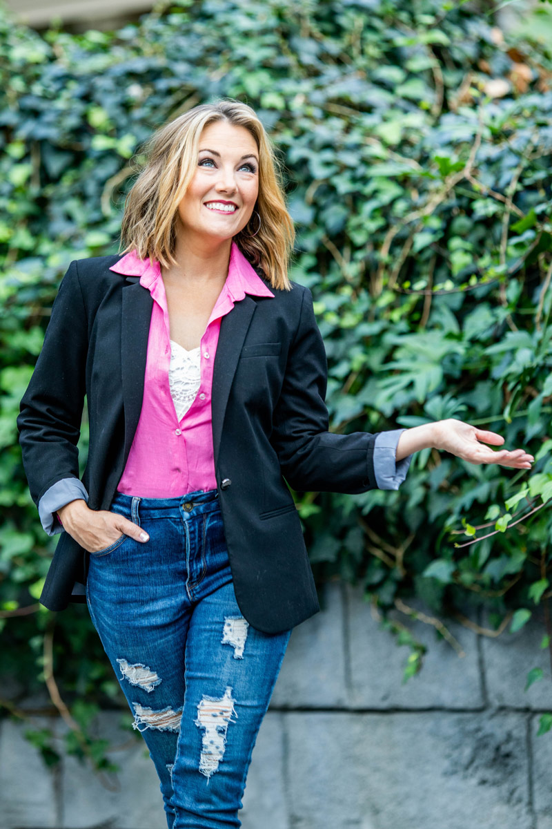 Elyssa standing in front of a vine-covered wall